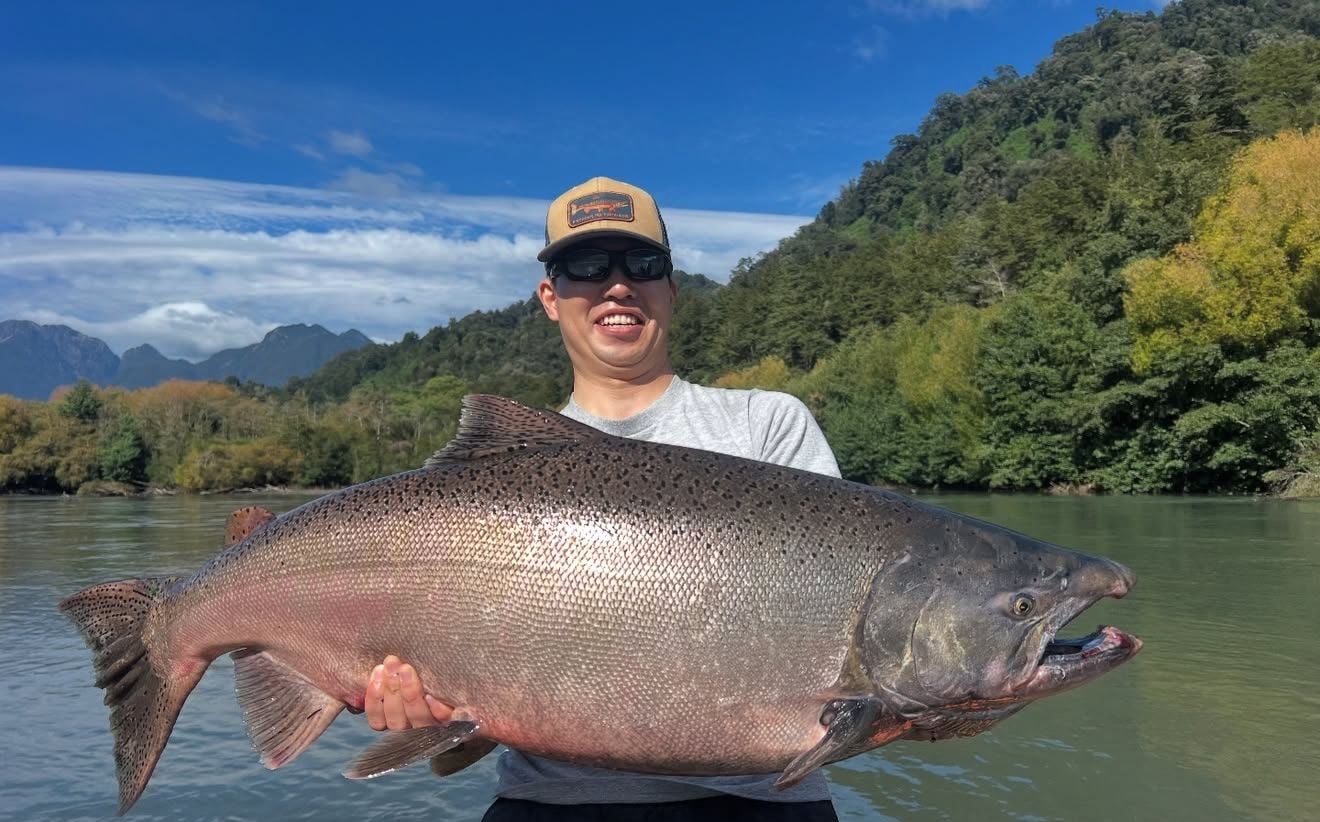 Gran captura en un río del sur rodeado de bosque y montaña